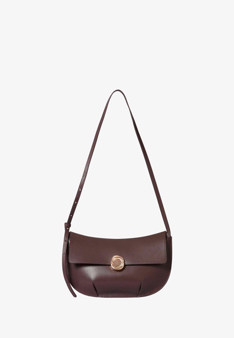 Borsa a spalla in pelle marrone con forma curva, dotata di un gancio circolare dorato e una lunga tracolla regolabile. Texture liscia e design minimalista.