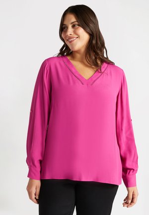 Fuchsia blouse met een V-hals, lange mouwen en subtiele uitsparingen langs de halslijn. Gemaakt van zachte stof, in een relaxte pasvorm.