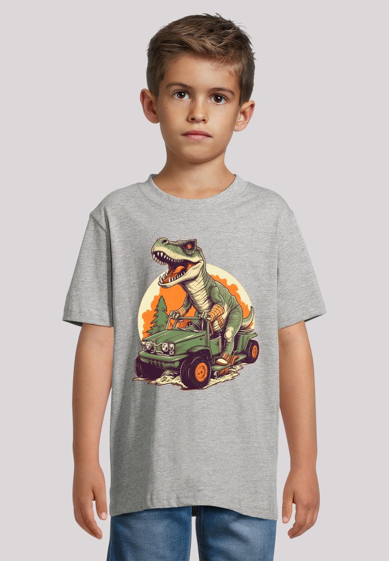 Grauer Baumwoll-T-Shirt mit einem bunten Dinosaurier-Design, der in einem olivgrünen Jeep fährt, mit orangefarbenen Akzenten und einem Sonnenuntergangshintergrund.