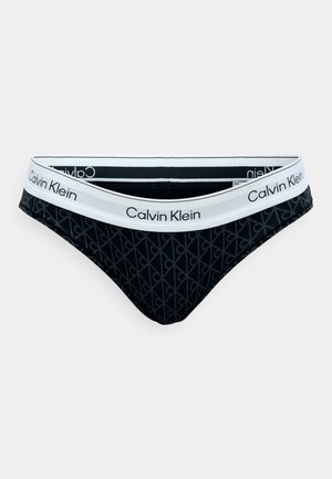 Calvin Klein svarte bikinioverdeler med hvit logo på midjebåndet. Har et mykt, elastisk materiale og et subtilt geometrisk mønster på stoffet.