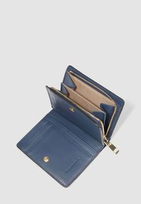 Cartera de cuero azul abierta que muestra ranuras para tarjetas y un compartimento para monedas con cremallera, forrado con tela beige.