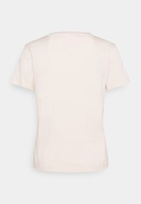 Camiseta corta de manga corta color beige claro, hecha de material suave, con cuello redondo y un diseño simple, sin adornos. Vista trasera lisa.
