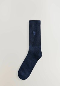 Navy gerippte Baumwollsocke mit einer soliden Textur, die ein dezentes Logo-Detail nahe dem oberen Rand und eine verstärkte Zehenpartie für zusätzliche Haltbarkeit aufweist.