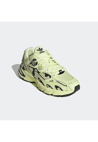 Scarpa da atletica verde lime con accenti neri. Presenta materiali in mesh e sintetico, una suola intermedia testurizzata e un sistema di allacciatura prominente.