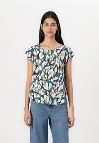 T-shirt à manches courtes dans un motif abstrait teal, crème et marine. Tissu léger, col rond, semi-ajusté, avec un ourlet incurvé.