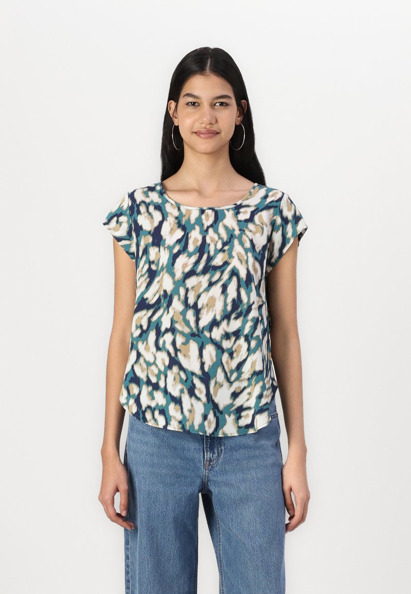 T-shirt à manches courtes dans un motif abstrait teal, crème et marine. Tissu léger, col rond, semi-ajusté, avec un ourlet incurvé.