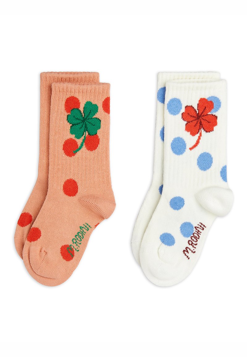 Deux paires de chaussettes pour enfants, l'une pêche à pois rouges et avec un trèfle à quatre feuilles vert, l'autre blanche à pois bleus et avec un trèfle à quatre feuilles rouge.