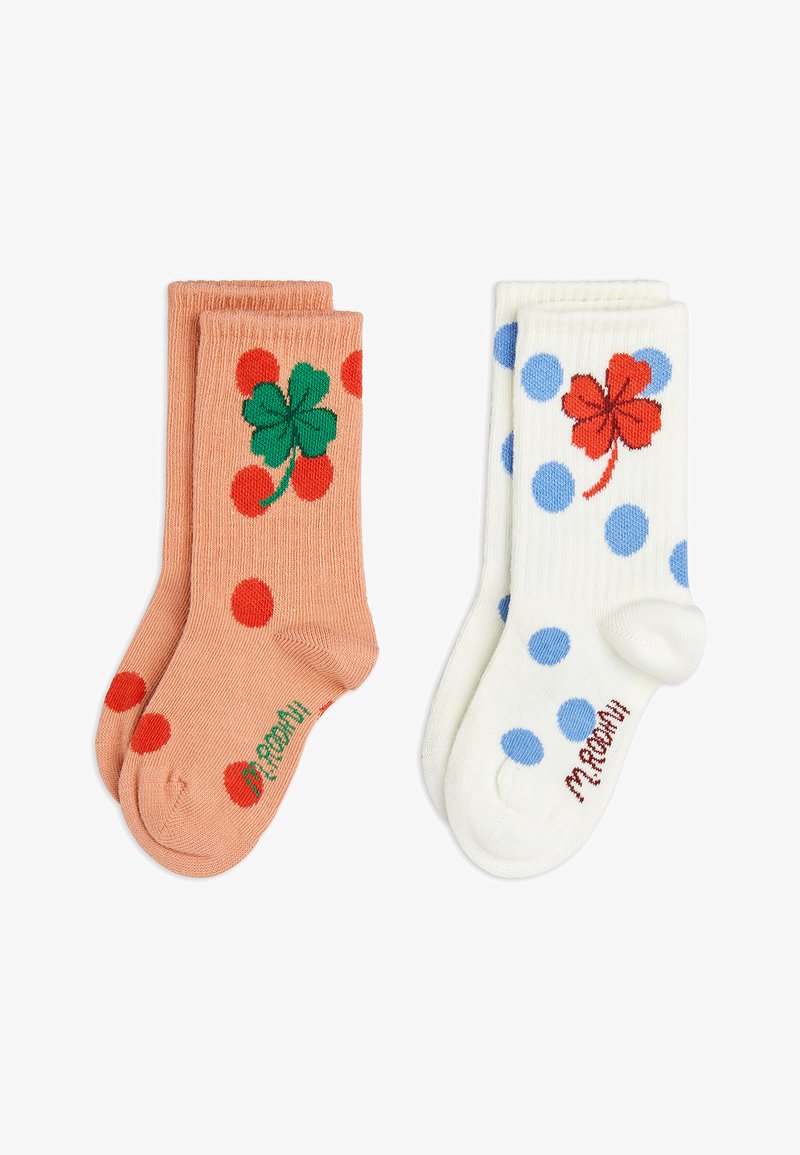 Zwei Paare Kindersocken, eines in Pfirsich mit roten Punkten und einem grünen vierblättrigen Kleeblatt, das andere in Weiß mit blauen Punkten und einem roten vierblättrigen Kleeblatt.