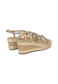 Sandali con zeppa beige, suola in juta intrecciata, dettagli metallici e cinturini incrociati. Presentano una chiusura con fibbia sul retro.