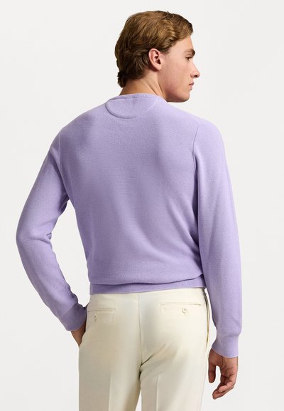 Lys lilla strikket sweater med lange ærmer og rund halsudskæring. Har et tekstureret mønster samt ribbede manchetter og kant.