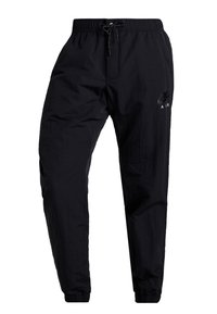 Černé nylonové joggingové kalhoty Nike Air s elastickým pasem, stahovací šňůrkou, bočními kapsami a elastickými manžetami na kotnících.