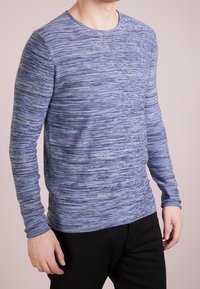 Long-sleeve blue textured shirt with a round neckline, featuring a horizontal stripe pattern in varying shades of blue. Smooth fabric.