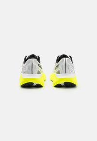 Graue Laufschuhe mit einem strukturierten Mesh-Obermaterial, schwarzen Akzenten und leuchtend gelben Gummisohlen. Verfügt über einen gepolsterten Schaft und reflektierende Details.