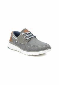 Las zapatillas de lona grises tienen cordones de un gris claro, un acento de cuero marrón en el talón y una suela de goma blanca flexible con detalles texturizados.