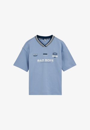 Hellblaues V-Ausschnitt-Kurzarmhemd mit marineblau gestreiftem Kragen und weißem Text "BAD BOYS," "Soccer League" und "Since 1988" auf der Vorderseite.