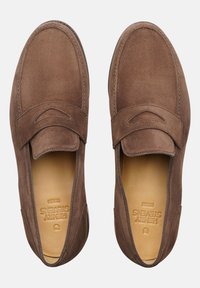 Mocassini in suede marrone con una fascia a penny e una morbida fodera in pelle, caratterizzati da una punta tonda e dettagli di cucitura minimali.