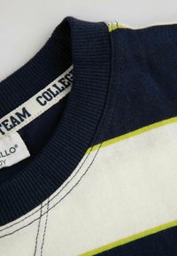 Granatowa bawełniana koszulka z kołnierzykiem prążkowanym, poziomymi paskami w kolorze białym i limonkowym, z widocznymi detalami przeszycia.