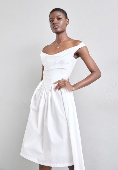 Witte off-shoulder jurk met een aansluitende lijfje en een geplooide rok. Beschikt over een textiele stof en een decoratieve accent bij de taille.