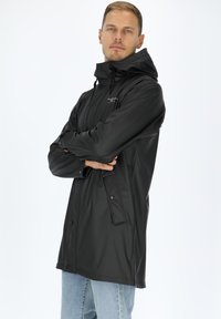 Zwarte waterdichte jas met capuchon, voorzien van een voorrits, drukknoopsluiting en twee zijzakken. Glad textuur met een slim-fit ontwerp.