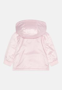 Svetle růžová saténová bunda s kapucí, žebrovanými manžetami a hladkým povrchem, s jednoduchým designem a mírně lesklým povrchem.