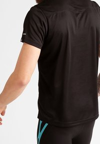 Black short-sleeve athletic shirt features a smooth texture and reflective accents on the sleeves, designed for active wear.