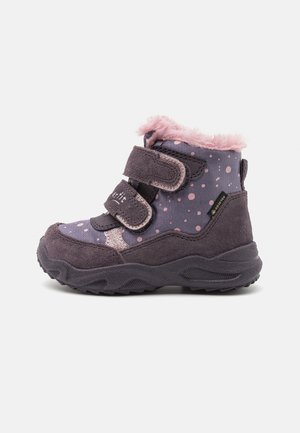 Stivaletto viola con pois rosa, bordo in pelliccia sintetica e cinturini in velcro. Materiali in suede e sintetici, suola in gomma testurizzata per una buona presa.