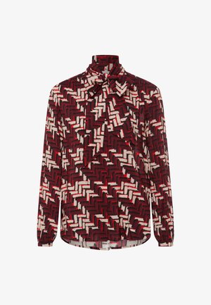 Blouse à manches longues en motif géométrique rouge et blanc avec un nœud au niveau du col, fabriquée en tissu léger, avec une coupe décontractée.