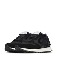 Un paio di sneaker nere in suede e tessuto con lacci neri, suola bianca e dettaglio imbottito sul tallone, su sfondo bianco.