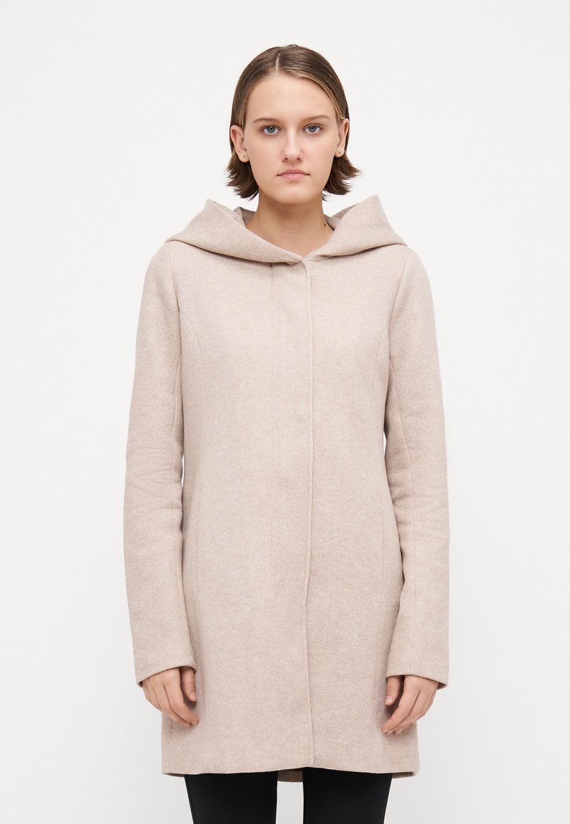 Helle beige Jacke mit Kapuze, maßgeschneiderter Schnitt, leicht strukturierten Stoff, langen Ärmeln und geradem Schnitt bis zur Mitte des Oberschenkels.