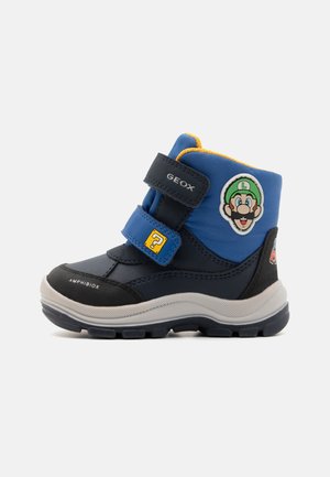 Bottes pour enfants bleues et noires avec un design imperméable, dotées de bandes velcro, d'une semelle en caoutchouc et d'un patch du personnage Luigi.