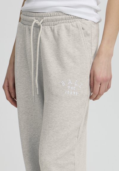 Svetlošedé tepláky vyrobené z mäkkého materiálu, s elastickým pásom so šnúrkou a bielym vyšívaným textom: "BALIT JEANS."