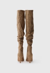 Stivali in camoscio beige, alti fino al ginocchio, morbidi e con punta affusolata e tacco stiletto, caratterizzati da una superficie liscia e dettagli di cucitura discreti.