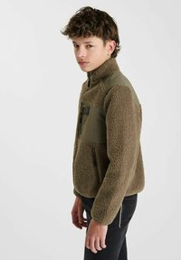 Bruine fleece jack met groene nylon panelen, hoge kraag, ritszak op de borst en zwarte ritsaccenten. Zachte textuur en casual ontwerp.