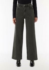 Jeans o szerokich nogawkach w ciemnoszarym denisie, z wysokim stanem, pięcioma kieszeniami i subtelnymi detalami w szwie. Gładka faktura i czyste wykończenie.