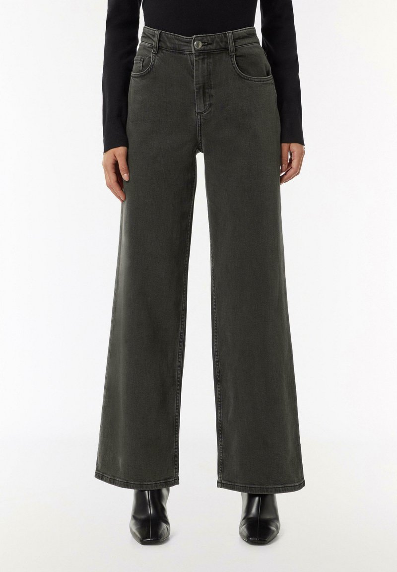 Jeans o szerokich nogawkach w ciemnoszarym denisie, z wysokim stanem, pięcioma kieszeniami i subtelnymi detalami w szwie. Gładka faktura i czyste wykończenie.
