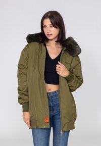 Olijfgroene bomberjack met faux fur kraag, ribgebreide manchetten, ritszakken en een ontspannen pasvorm. Gladde, iets glanzende stof.