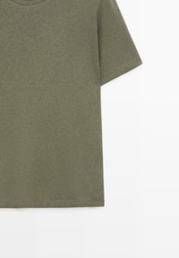 T-shirt en coton manches courtes vert olive avec col rond et ourlet droit, présenté sur fond blanc.