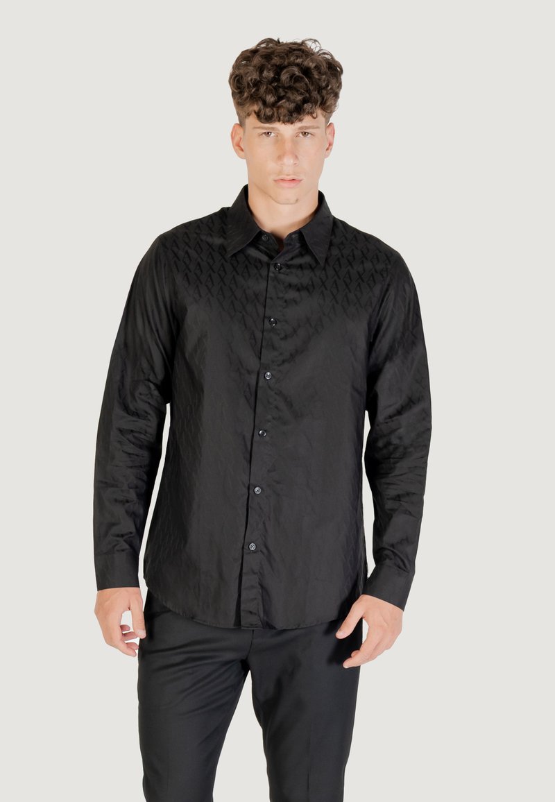 Camicia nera con bottoni, realizzata in tessuto testurizzato, caratterizzata da un sottile motivo geometrico sulla parte anteriore, maniche lunghe e orlo curvo.