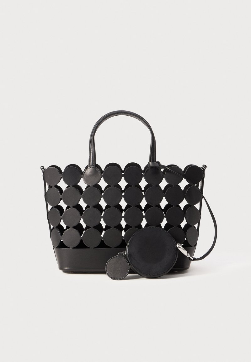 Sort tote bag med cirkulære udskæringer, syntetisk materiale, to håndtag og en aftagelig rund pung med lynlås. Glat tekstur, moderne design.