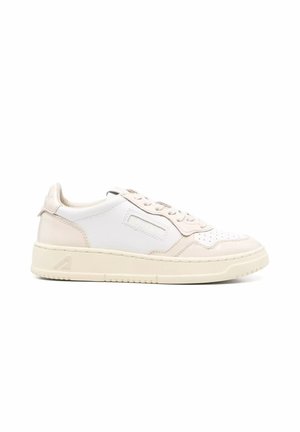Sneaker bassa in pelle bianco sporco con punta perforata, chiusura con lacci e suola spessa con logo in rilievo sottile sul lato.