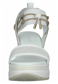 Sandale blanche à bout ouvert avec tige en mesh, accents élastiques et détails en métal doré. Semelle blanche épaisse avec un motif de grip texturé.