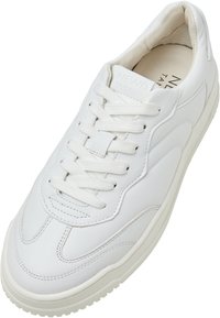 Weiße Leder-Sneaker mit runder Spitze, strukturiertem Obermaterial und tonalem Nähen. Verfügt über flache weiße Schnürsenkel und ein gepolstertes Innenleben.