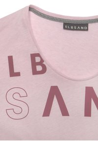 Lichtroze t-shirt met een ronde hals, voorzien van grote bordeauxrode letters die artistiek zijn gerangschikt en een visgraatpatroon op de halslijn.