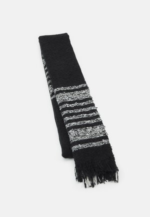 Écharpe en maille noire avec des rayures horizontales alternées blanches et noires et des extrémités à franges, pliée sur un fond blanc.