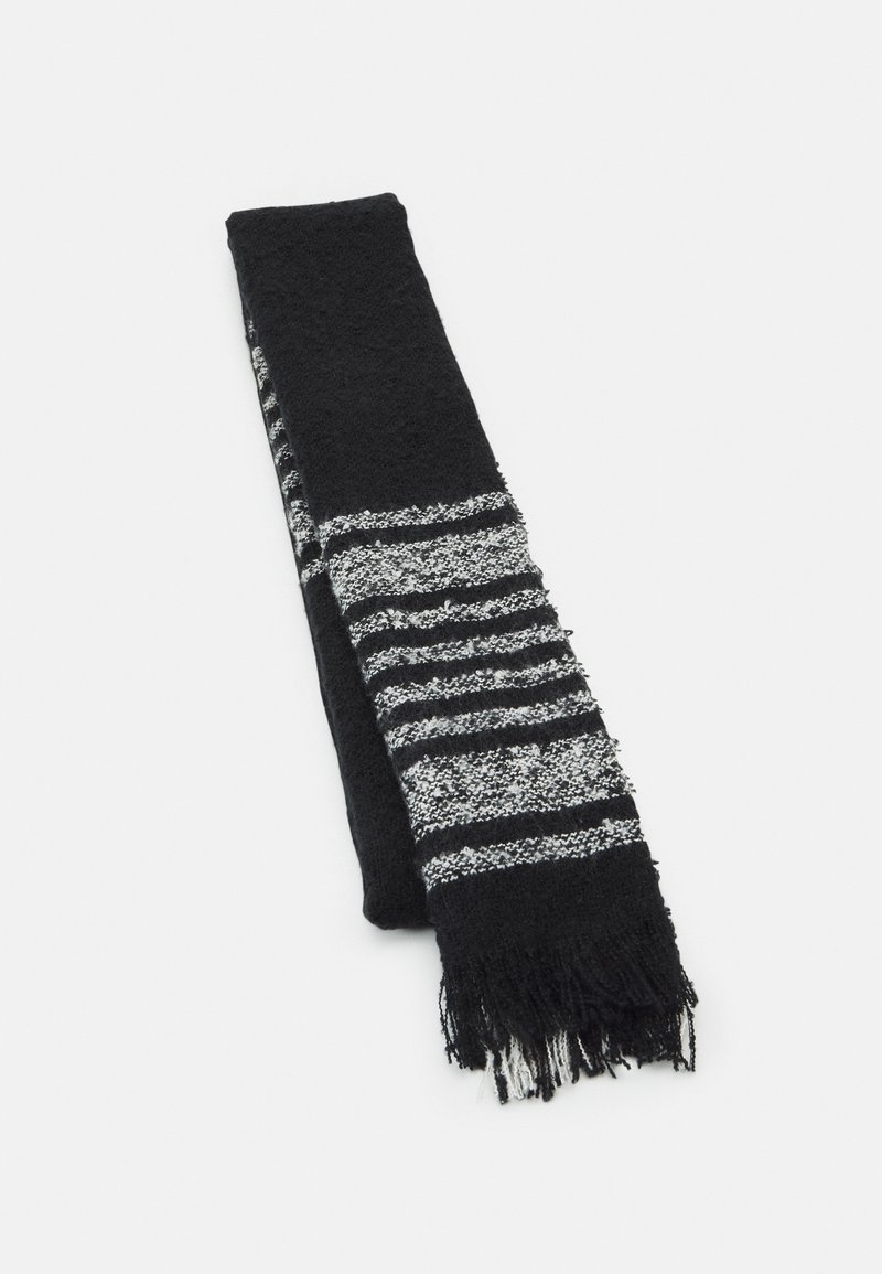 Écharpe en maille noire avec des rayures horizontales alternées blanches et noires et des extrémités à franges, pliée sur un fond blanc.