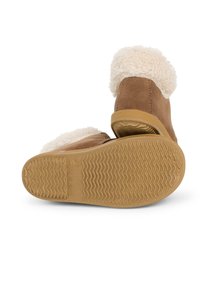 Botas de tobillo de ante marrón con un lujoso cuello de piel sintética en color crema, suela de goma con patrón texturizado y cremallera lateral para ponerlas y quitarlas fácilmente.