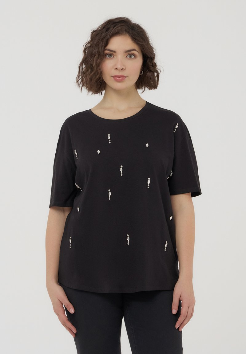 Maglietta nera in tessuto morbido, con accenti decorativi in rilievo di colore argento. Vestibilità rilassata con maniche corte e scollo tondeggiante.