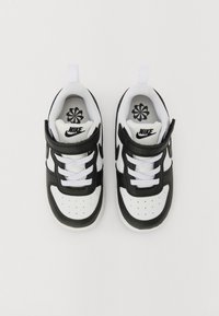 Baskets Nike noir et blanc avec une tige en cuir et en mesh, bout rond, col rembourré et lacets blancs avec une sangle velcro.