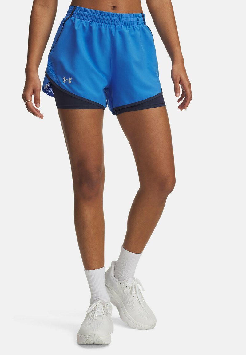 Shorts de sport bleu en matériau respirant, avec une superposition en mesh et des accents bleu marine, et une taille élastique pour le confort.