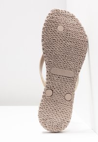 Sandalen-Sohle mit strukturiertem, seilähnlichem Muster und eingeprägtem Markennamen, zeigt Größenangaben US 7, EUR 37, UK 4.